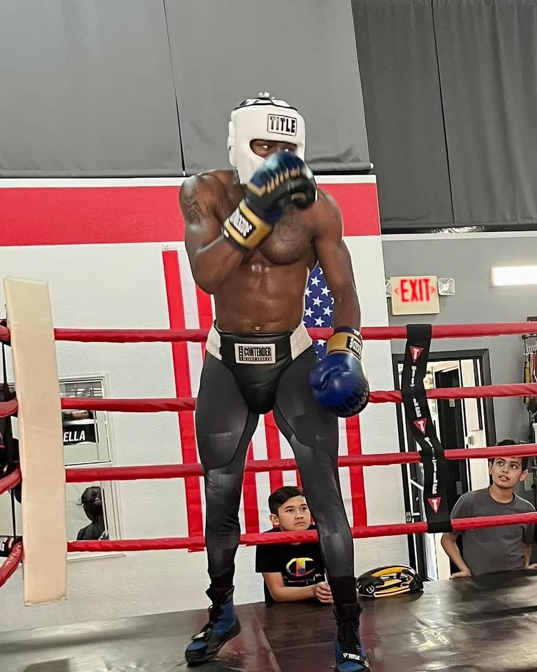 Fighter in headgear and gloves inside the boxing ring
