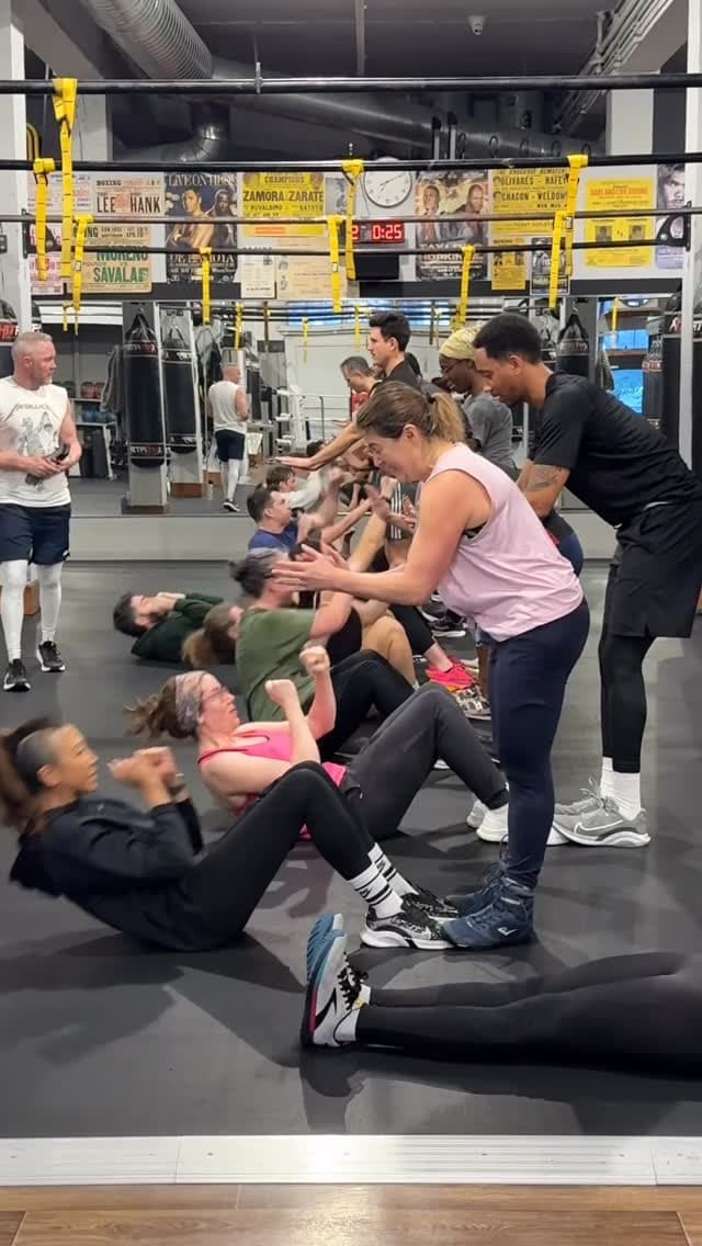 Coach Wayne Squires on the gym floor with battle ropes and heavy bags behind him